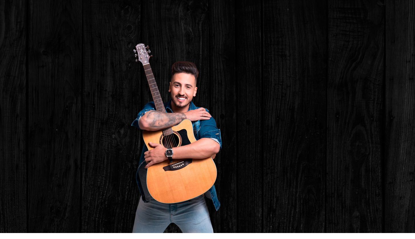 Gabriel Gadelha sorrindo com violão